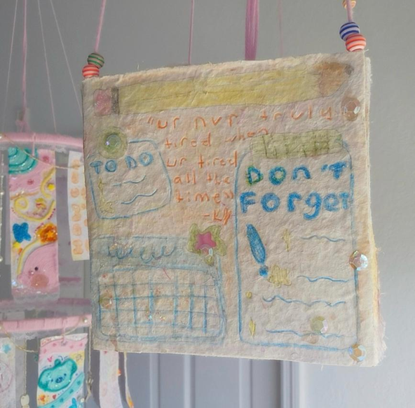 A paper lantern from Kiera’s project, “The Cutest Crashout in History.” The words read, “ur nvr truly tired when ur tired all the time,” with a drawing of a pencil, a to-do list, reminders, and a calendar.