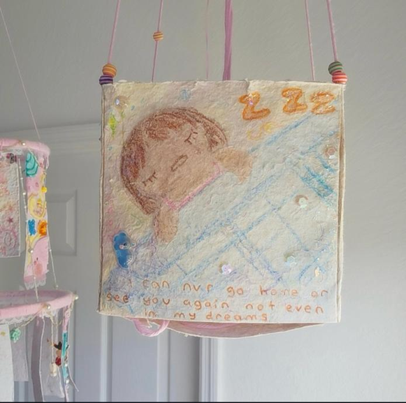 A paper lantern from Kiera’s project, “The Cutest Crashout in History.” The words read, “I can nvr go home or see you again not even in my dreams,” with a drawing of a girl in bed.