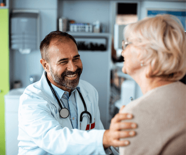 Doctor with hand on the shoulder of female patient.