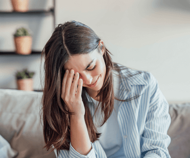 Woman with hand on face - she seems tired with a headache