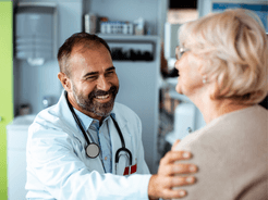 Doctor with hand on the shoulder of female patient.